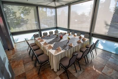 Banquet-style meeting space in Vip Private room featuring table with black runners and grey seating at Hotel Mirra