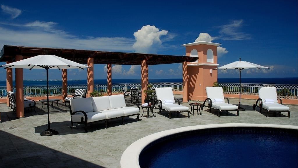 Outdoor pool with sun loungers & patio umbrellas at Grand Fiesta Americana Hotel and Resorts