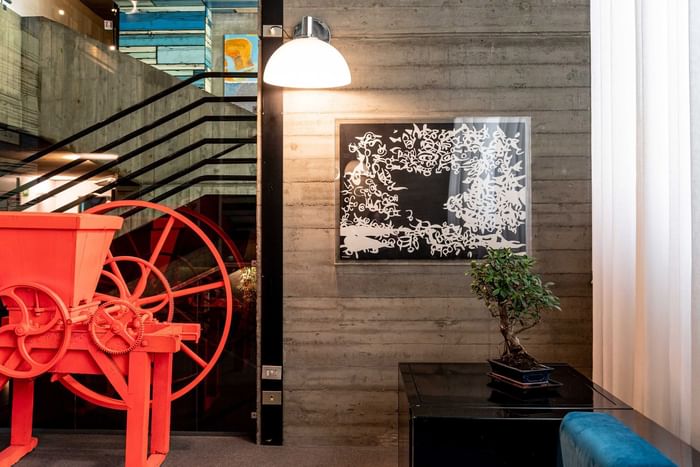 Lounge con opere d'arte contemporanea spigolatrice rossa Anselm Reyle e dipinto Carla Accardi su parete in cemento al DUPARC