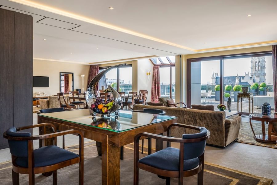 Luxe suite met eettafel en glazen balkondeuren bij Warwick Grand-Place Brussels.
