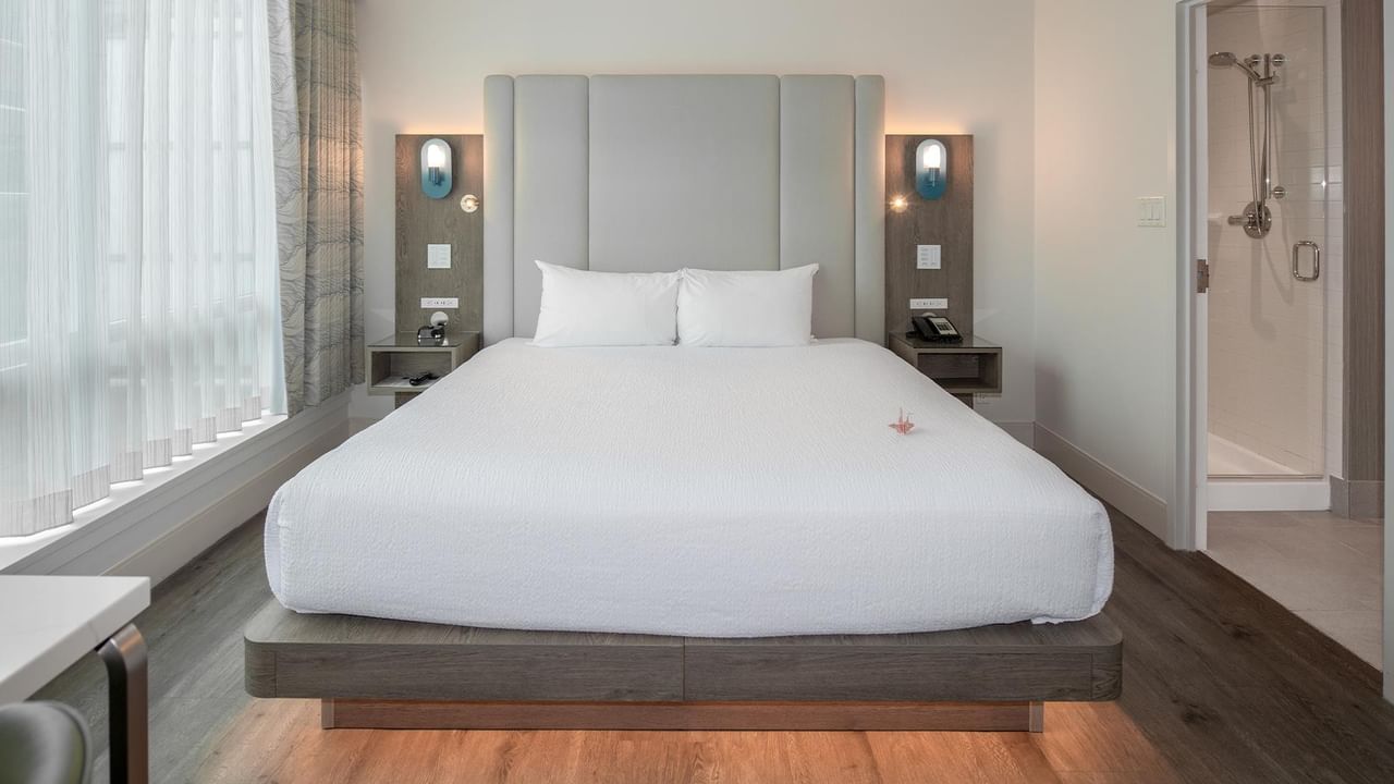 Hotel room with bed, nightstands, and bathroom.