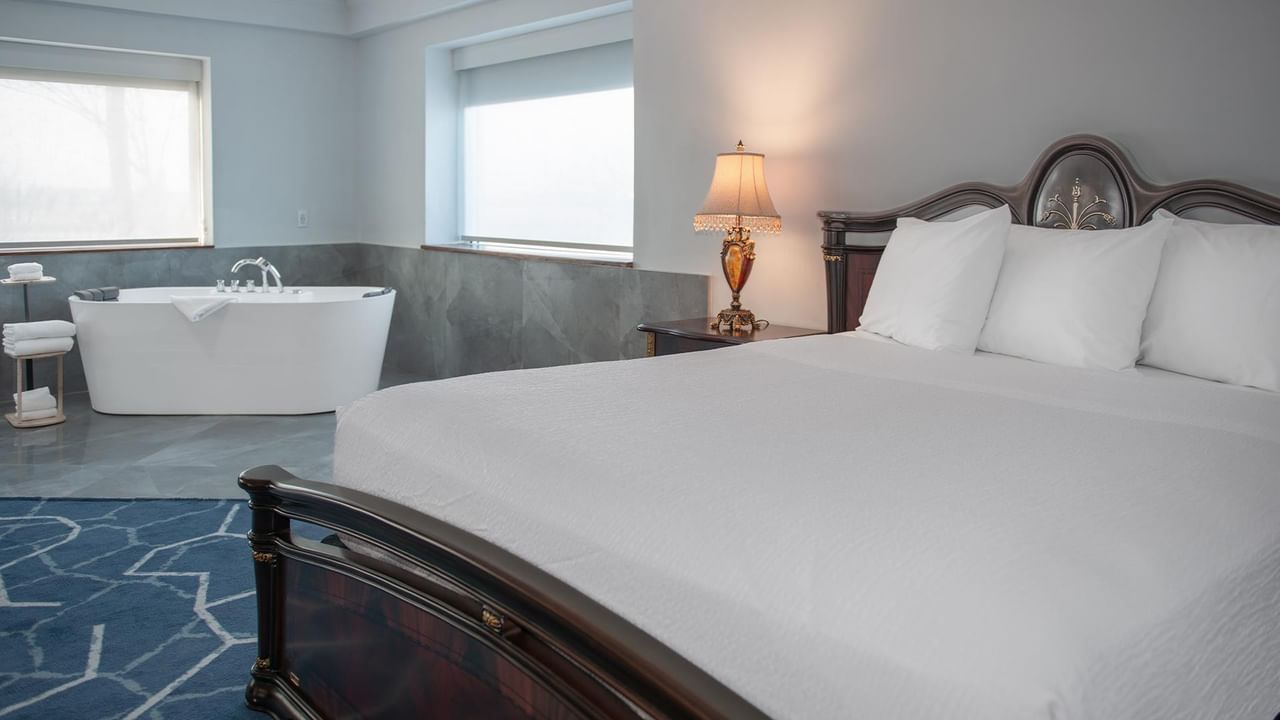 Hotel suite with large bed and a jetted tub.