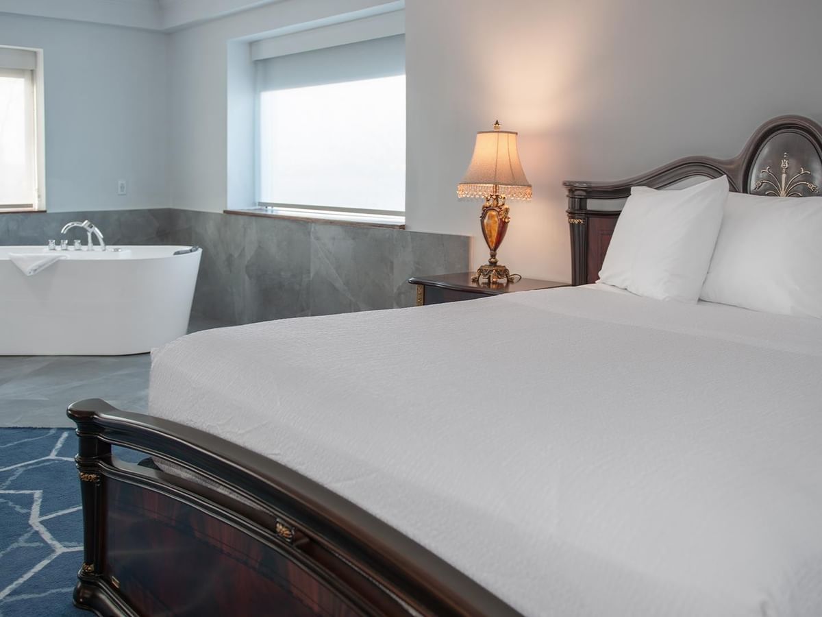 Spacious hotel suite with jetted tub and a queen bed.