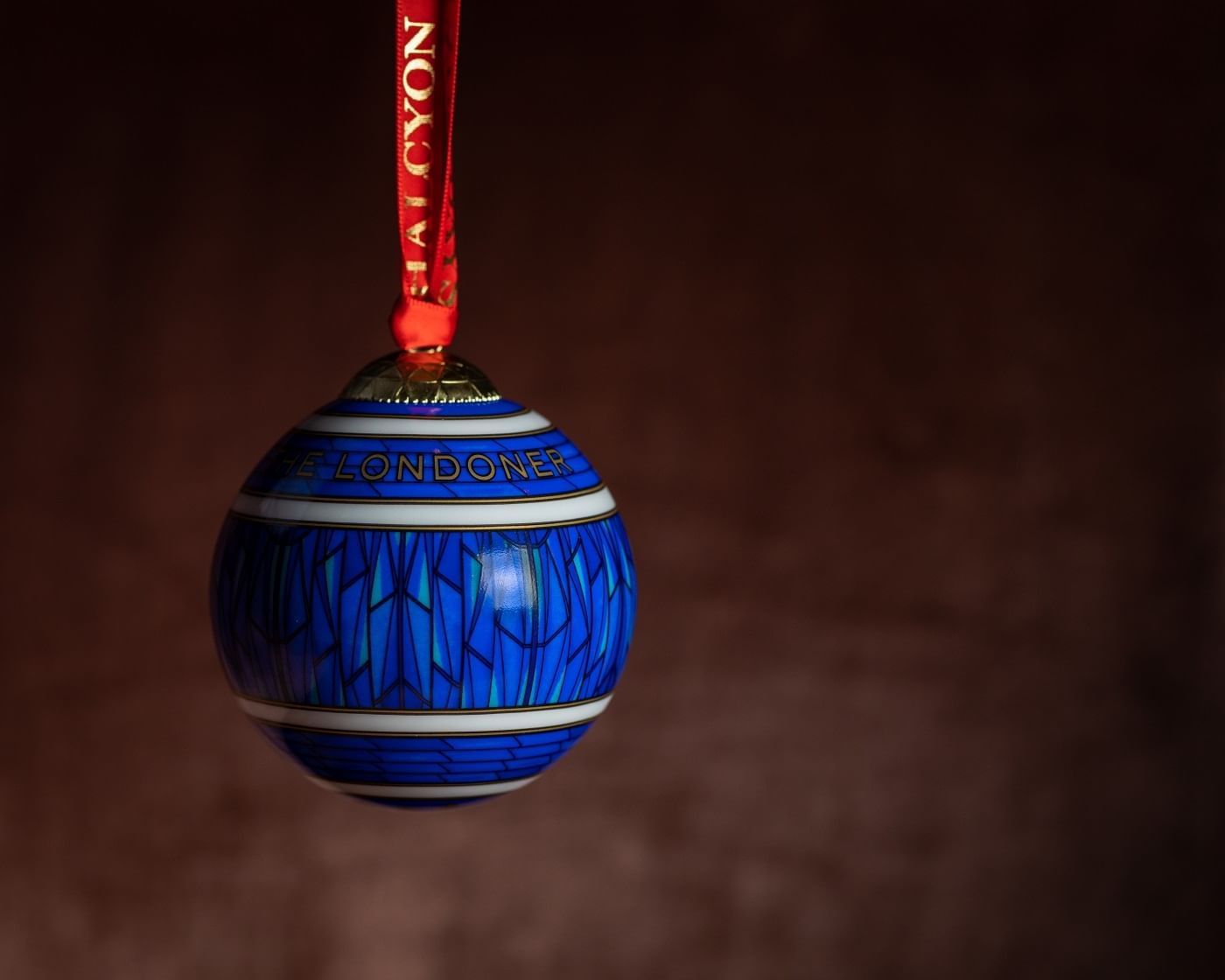 Close-up of a blue Christmas ball used for decoration with a maroon background at The Londoner Hotel
