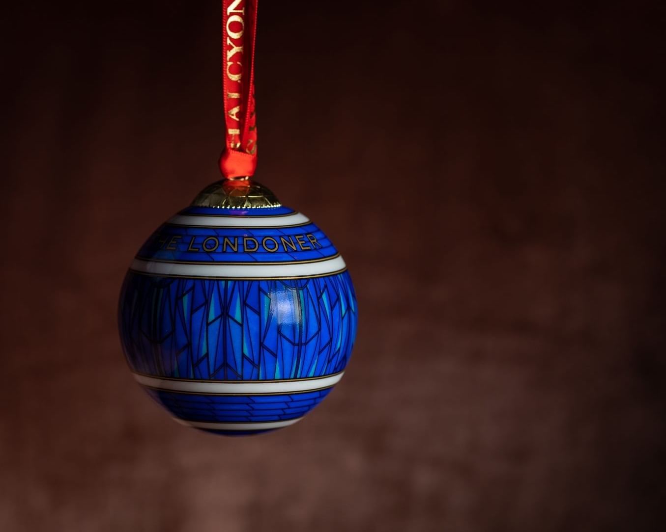 Close-up of a blue Christmas ball with a maroon background at The Londoner