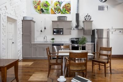 Kitchen with appliances & dining table in Executive Residences at Retro Suites Hotel