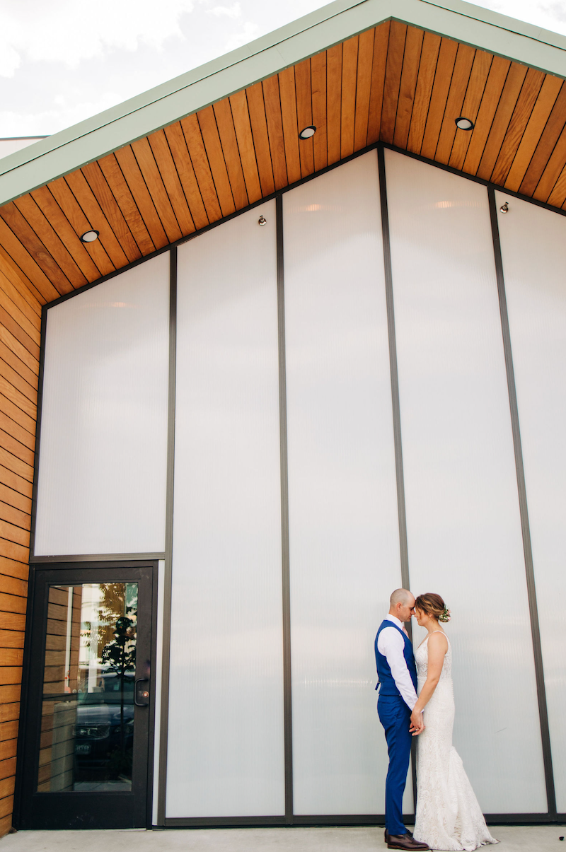 Wedding couple posing in front of the hotel at Kinship Landing