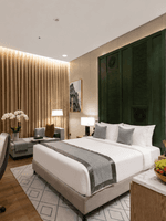 Table near bed beside daybed in Deluxe Room at Naviti by Warwick Jeddah, capturing stylish hotel rooms in Jeddah