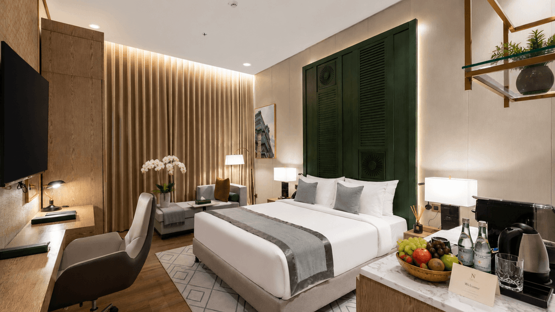 Table near bed beside daybed in Deluxe Room at Naviti by Warwick Jeddah, capturing stylish hotel rooms in Jeddah