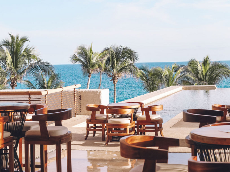 Outdoor dining area with a pool & sea view at Marquis Los Cabos