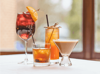 Variety of colorful and sophisticated cocktails arranged on a bar top in Epoch Restaurant & Bar at The Exeter Inn