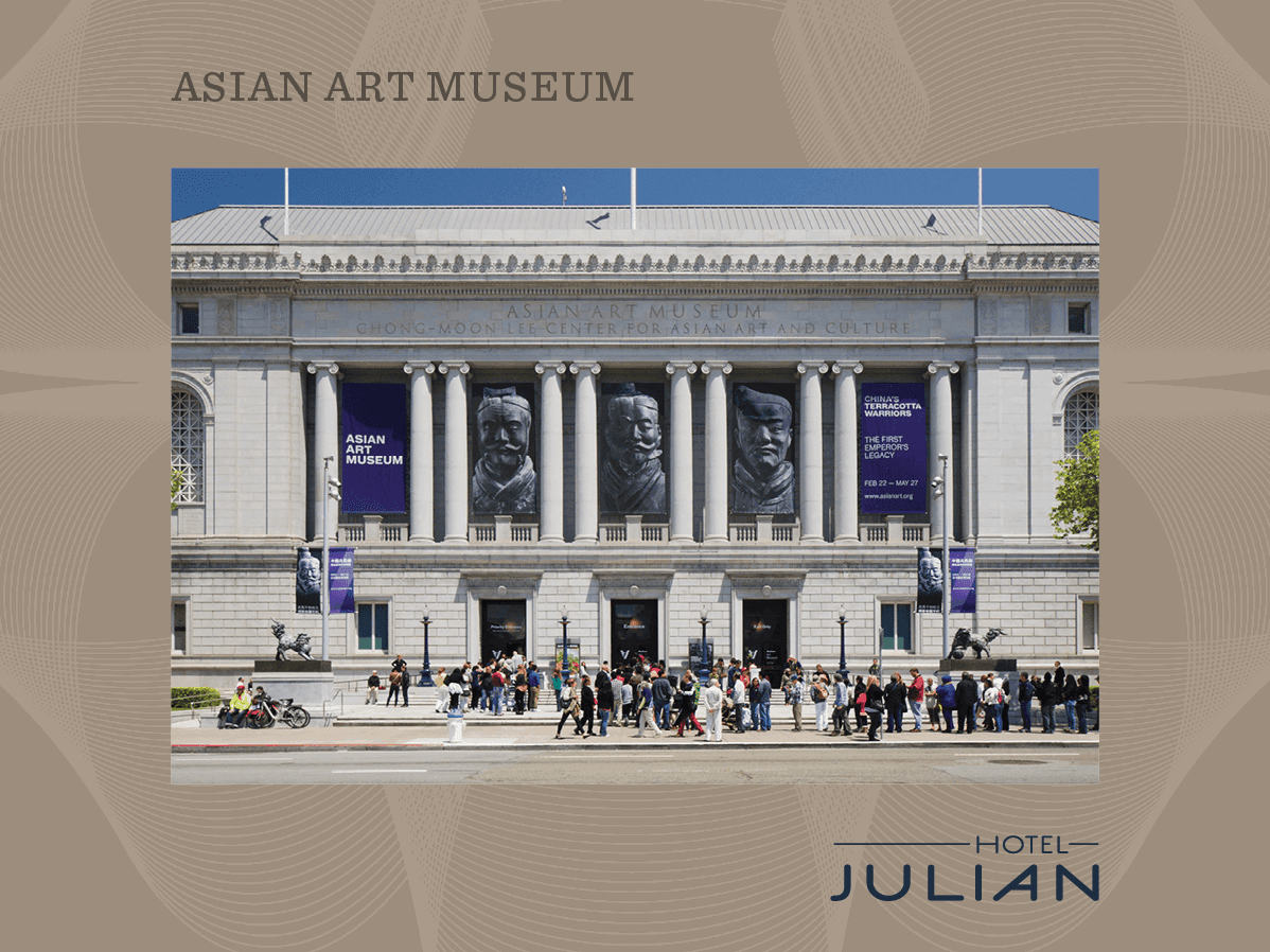 A large white building with columns and a crowd of people in front of it.