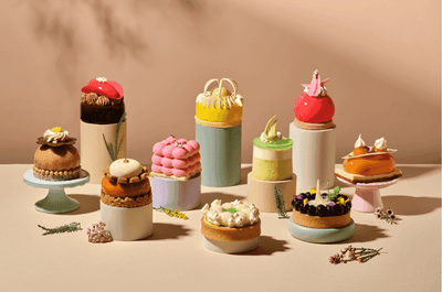 A stunning collection of colorful and intricate miniature pastries arranged artfully at the Carlton Hotel Singapore