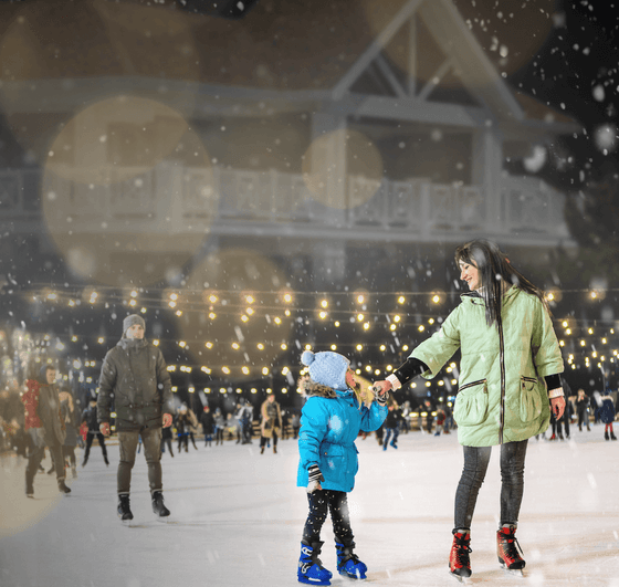 Mom and son ice skate on the rink at our Avalon hotel