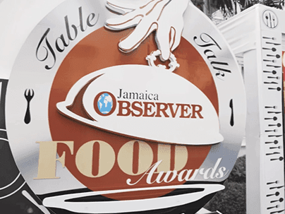 Table Talk Jamaica Observer Food Awards promo banner showing silver cloche and plate sign near Jamaica Pegasus Hotel