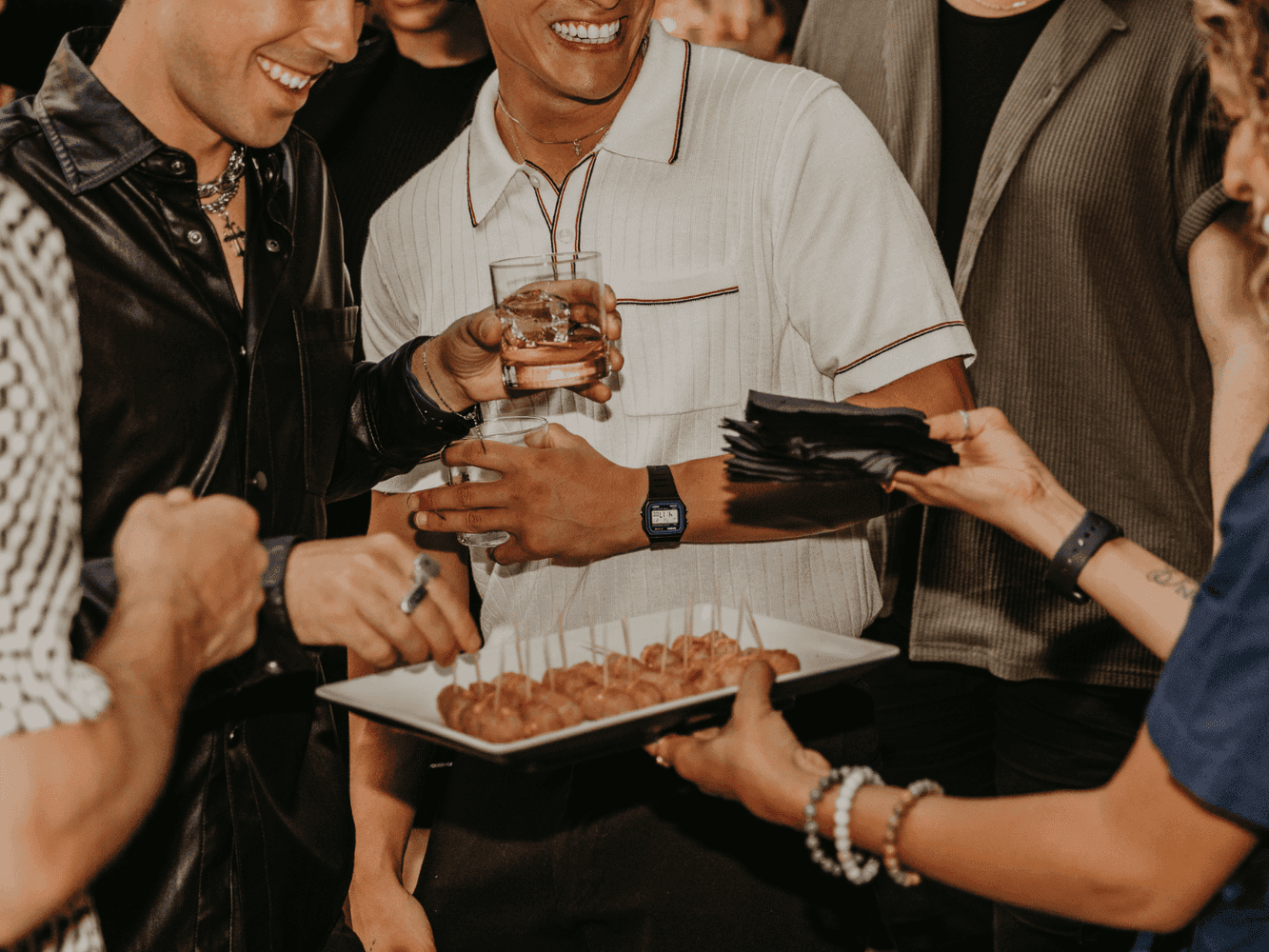 Group of people taking food from a serving plate