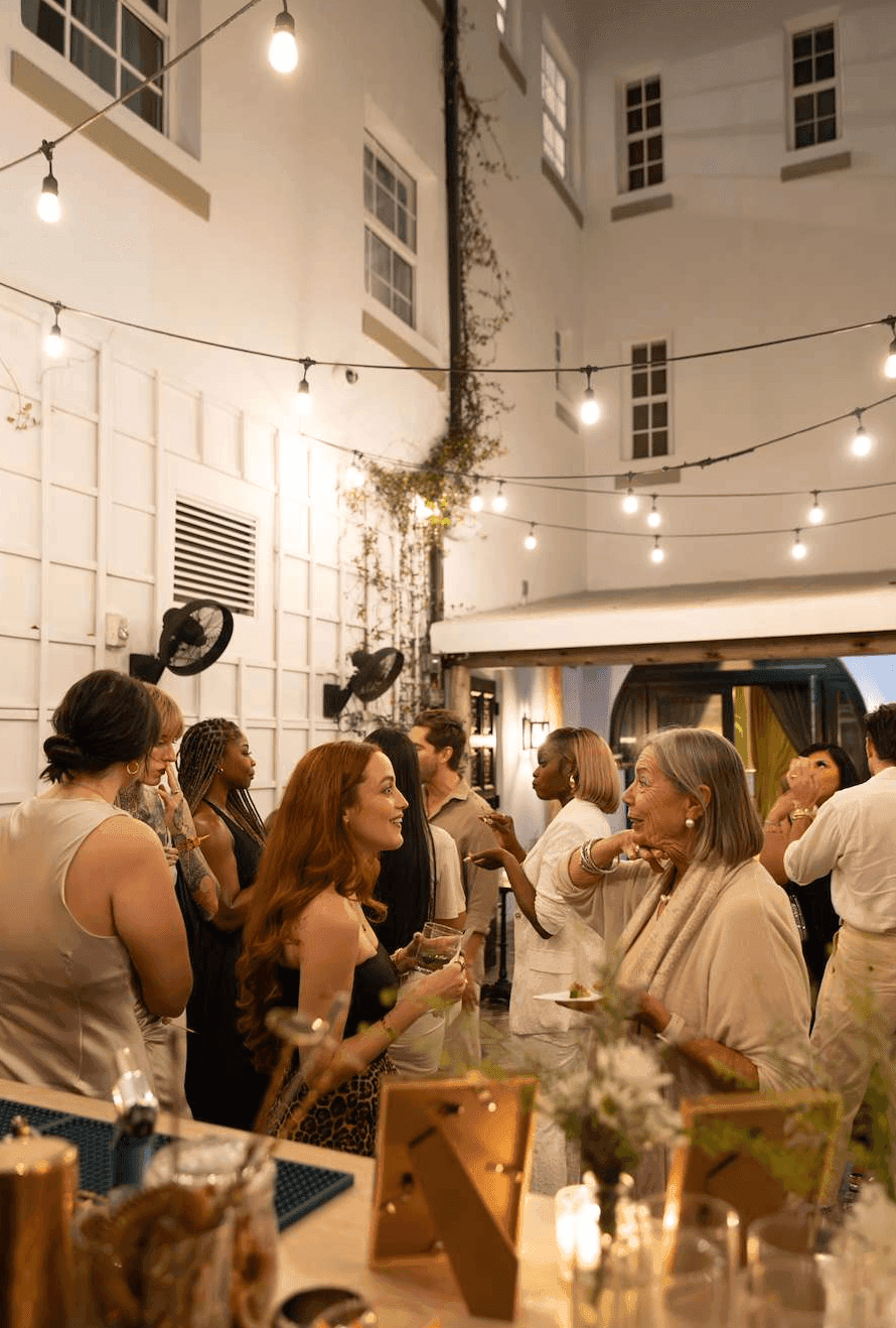 A group of people socializing at a bar with string lights
