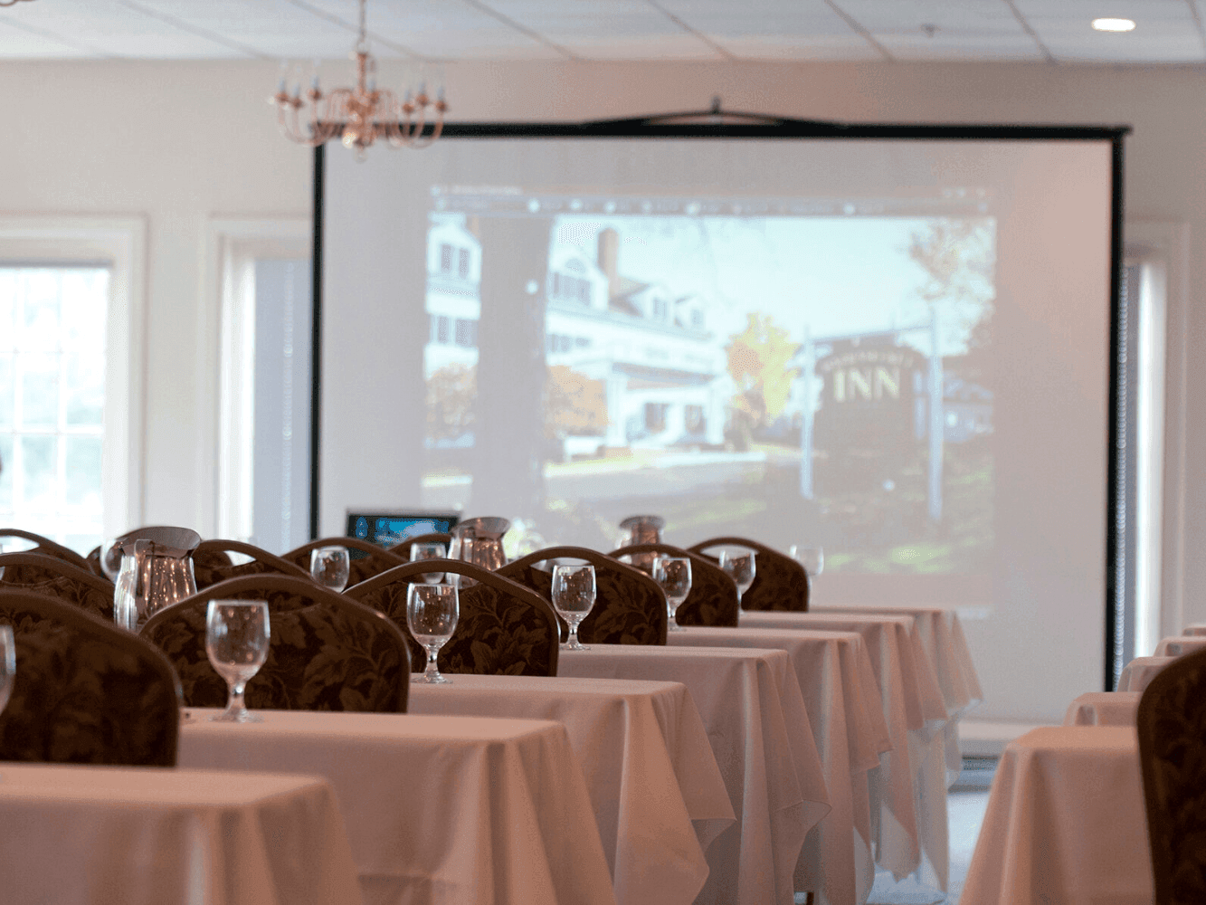 Classroom type table setup arranged for a presentation in Cathance Room at Harraseeket Inn