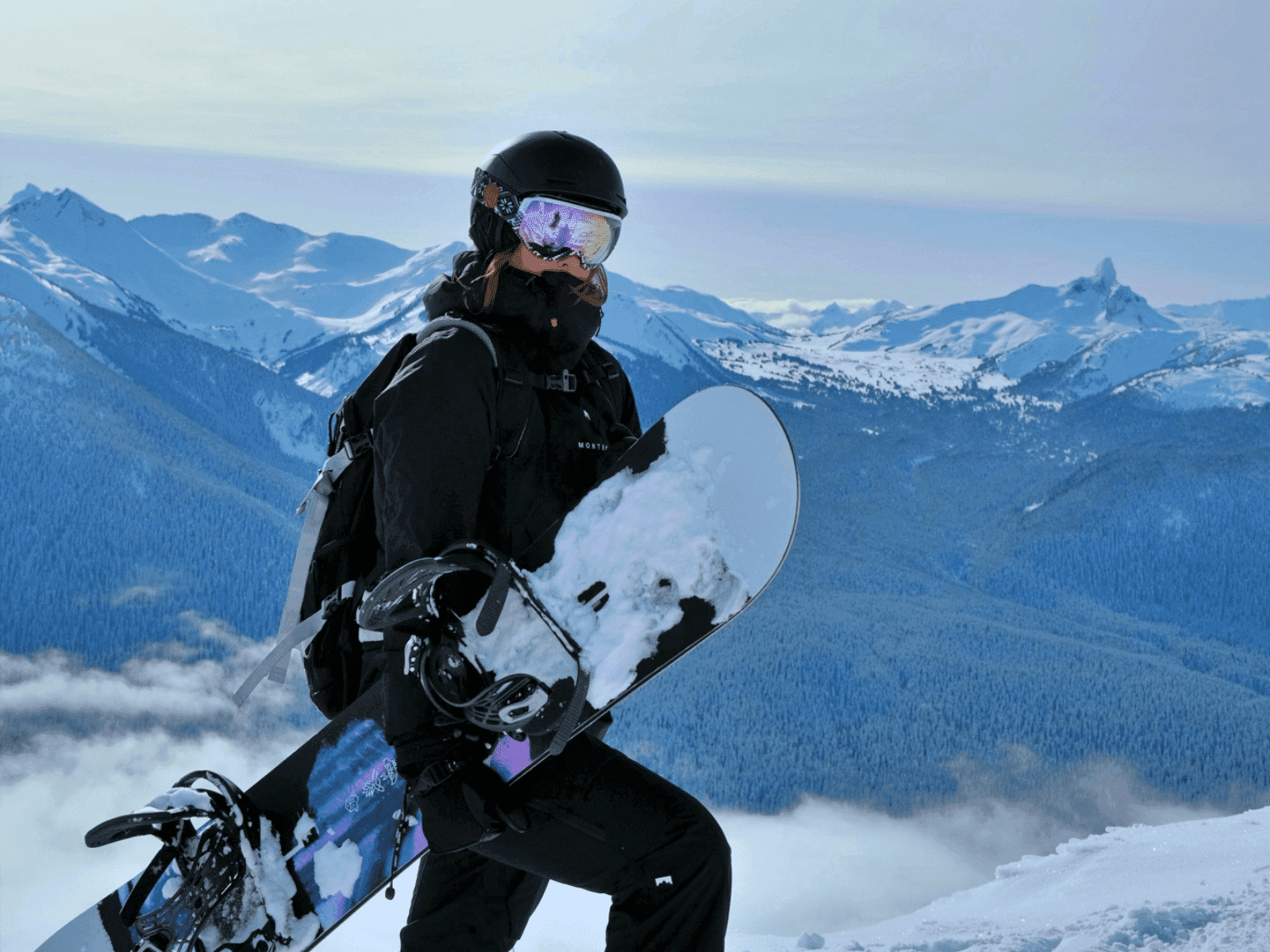 Winter skier enjoying Whistler Mountain's slopes, dressed in vibrant ski gear, against a snowy backdrop of trees and slopes.