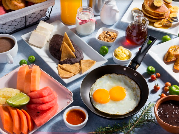 Breakfast table with fruits, eggs, pancakes and beverages served at Porta Hotel del Lago