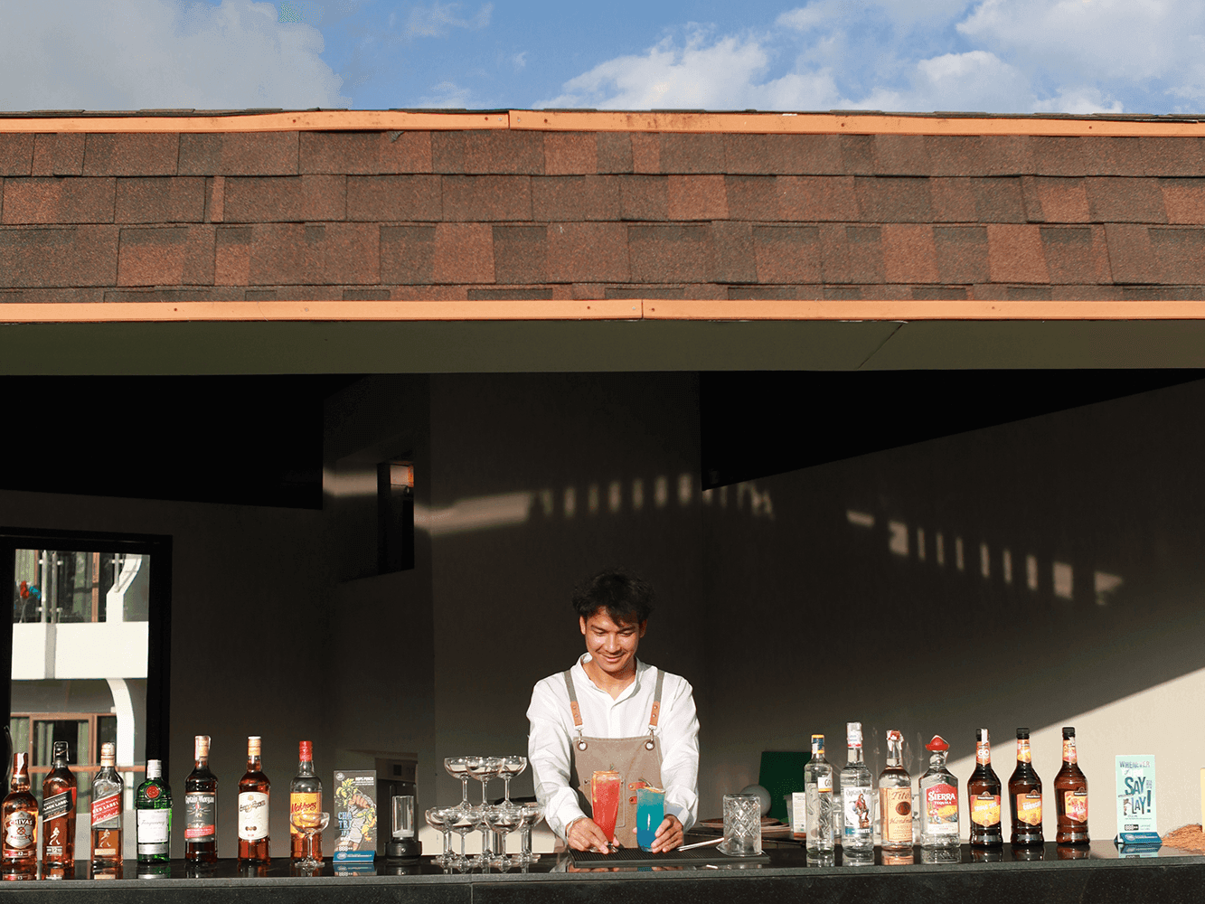 Lounge area in Astra Rooftop with bright orange bean bags on green turf under a sunny sky at Amora Beach Resort Phuket, 