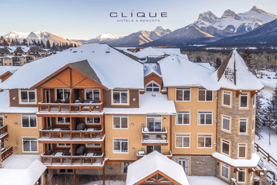 Aerial view of the snow-dusted Falcon Crest Lodge backdrop of majestic snow-capped mountains under a clear sky