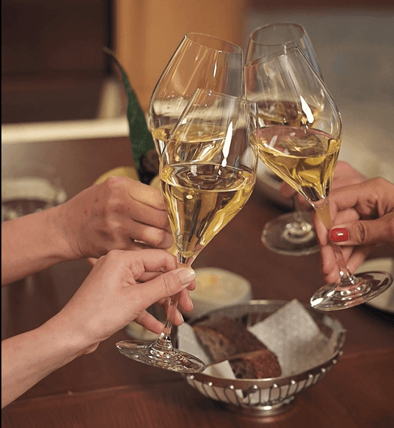 Close-up of friends toasting wine glasses at Almanac X Alcron Prague, Fine Dining Prague