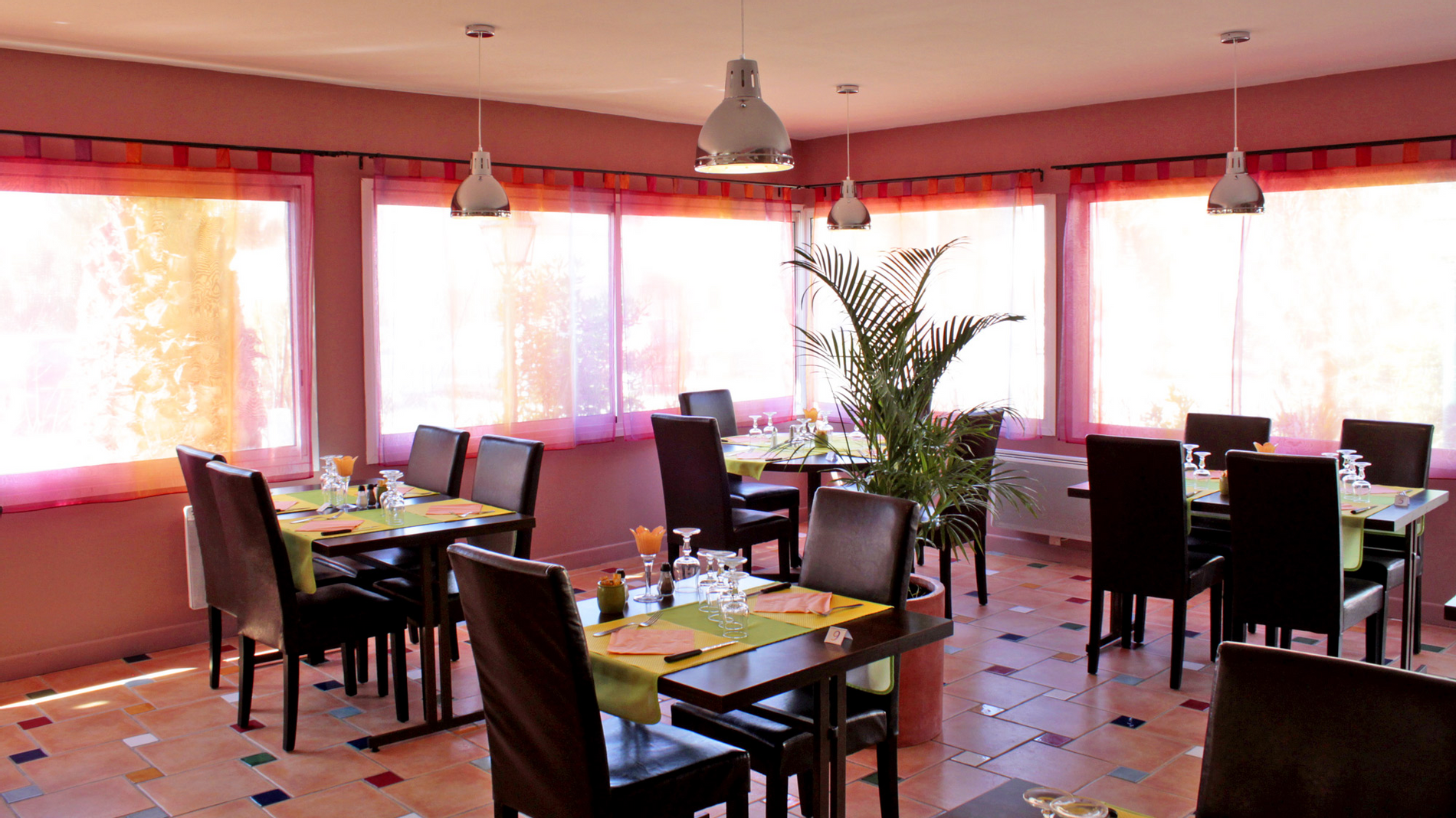 Arranged chairs & tables with glasses at The Originals Hotels