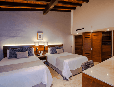 Deluxe Two Double Beds Ocean View interior with closet and work desk at Buenaventura Grand Hotel and Spa