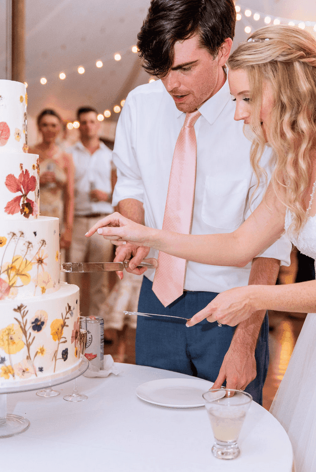 Bride and groom cutting a floral-designed wedding cake at the Clifton Hotel in Charlottesville, VA.