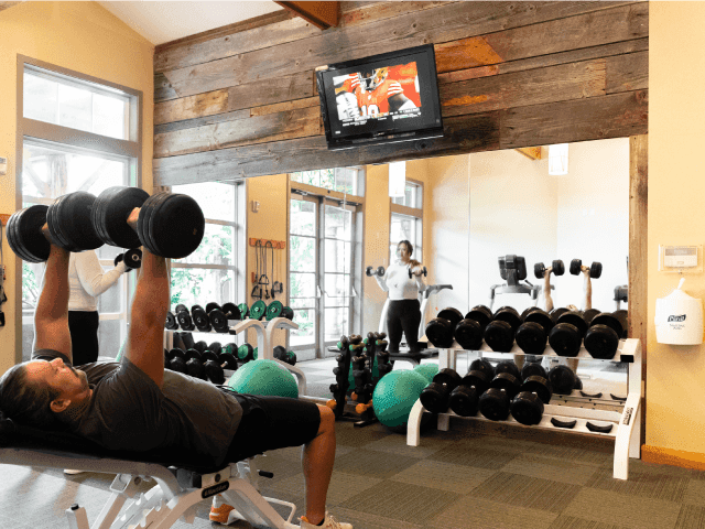 A man lifting dumbells in the Fitness Center at Alderbrook Resort & Spa
