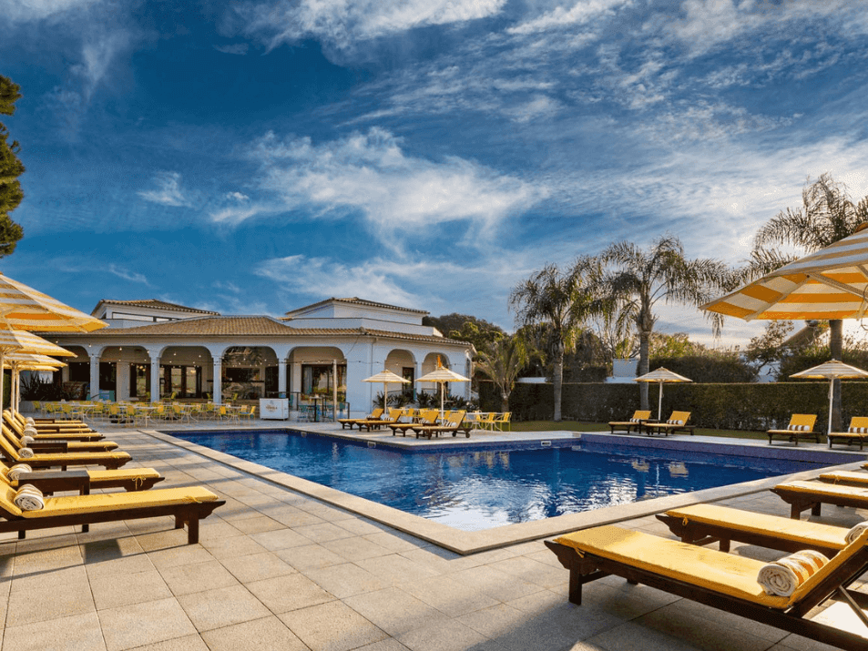 Exterior and sky view of outdoor pool area with pool beds and umbrellas in pool bar at The Magnolia Hotel