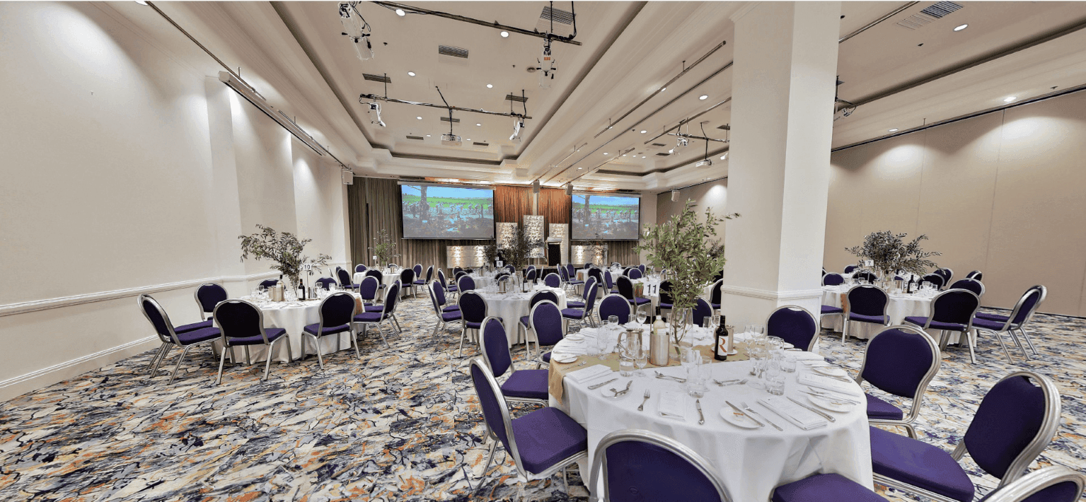 Banquet hall with round tables and chairs at Grand Chancellor Adelaide