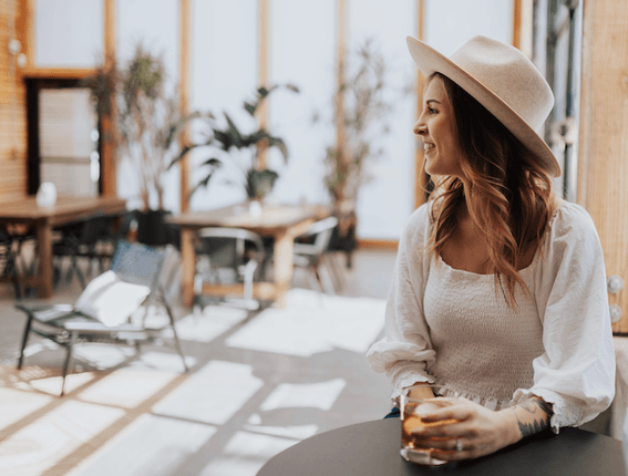 Woman having a drink in the lounge area at Kinship Landing