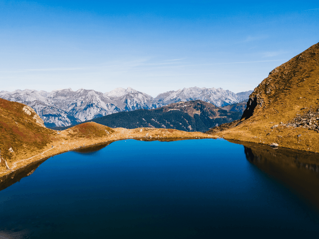 Lake Schwarzsee surrounded by lush mountains near Hotel des Innovations