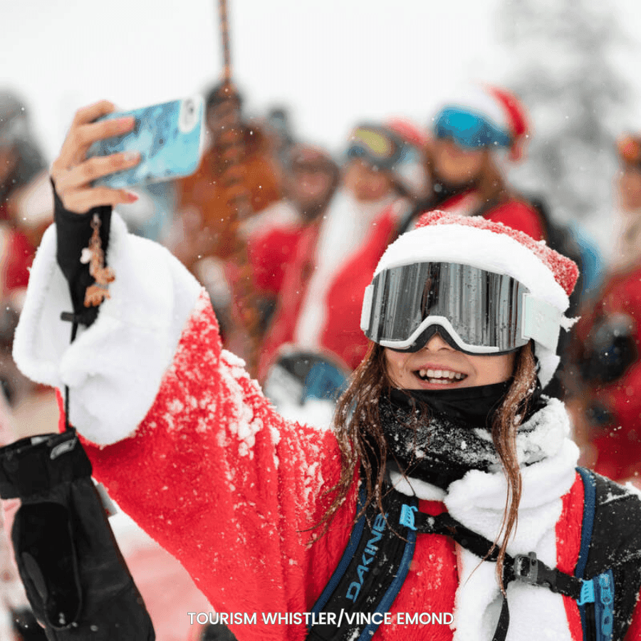 Girl in Santa suit taking selfie with group of people near Blackcomb Springs Suites