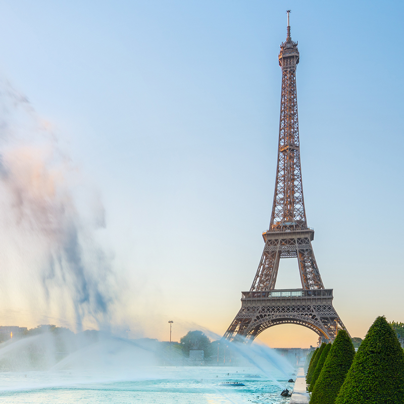 Eiffel Tower at sunrise, surrounded by water fountains, near Warwick Hotels and Resorts