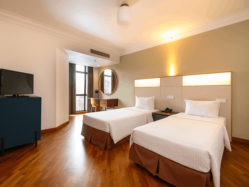 TV, workspace, and wall-mounted mirror by the cozy beds in the Superior Twin Room with hardwood floors at YWCA Fort Canning