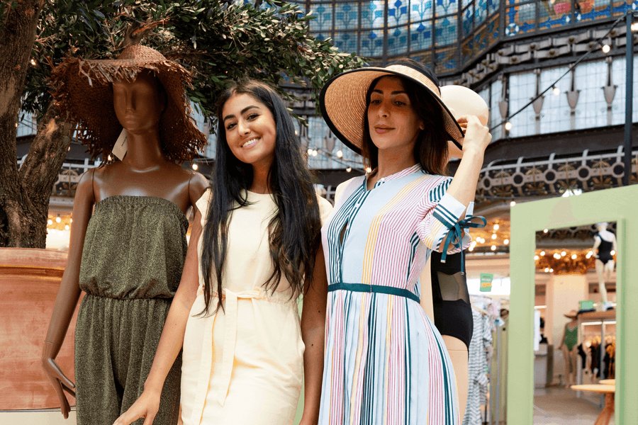 Trois femmes élégantes en robes d'été posent dans une galerie commerciale parisienne à l'Hotel Westminster Warwick Paris