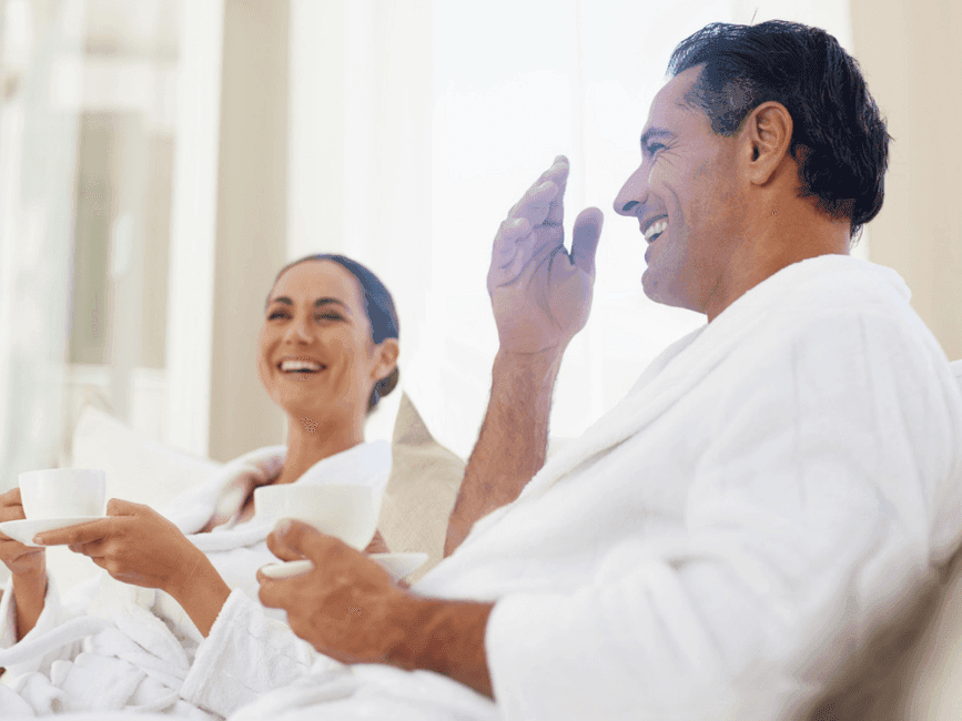 A couple in robe enjoying coffee at Amora Hotel