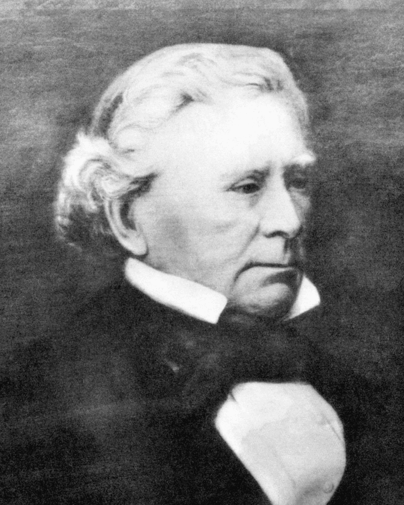 Black and white portrait of an elderly man with white hair and bow tie, looking slightly off-camera.