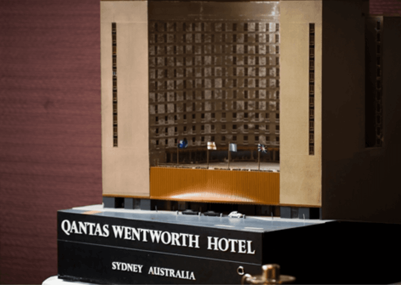 A model of the Qantas Wentworth Hotel with a brown building and flags on the balcony.