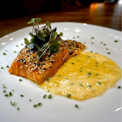 Close-up of a finely plated salmon dish served at Ivey's Hotel