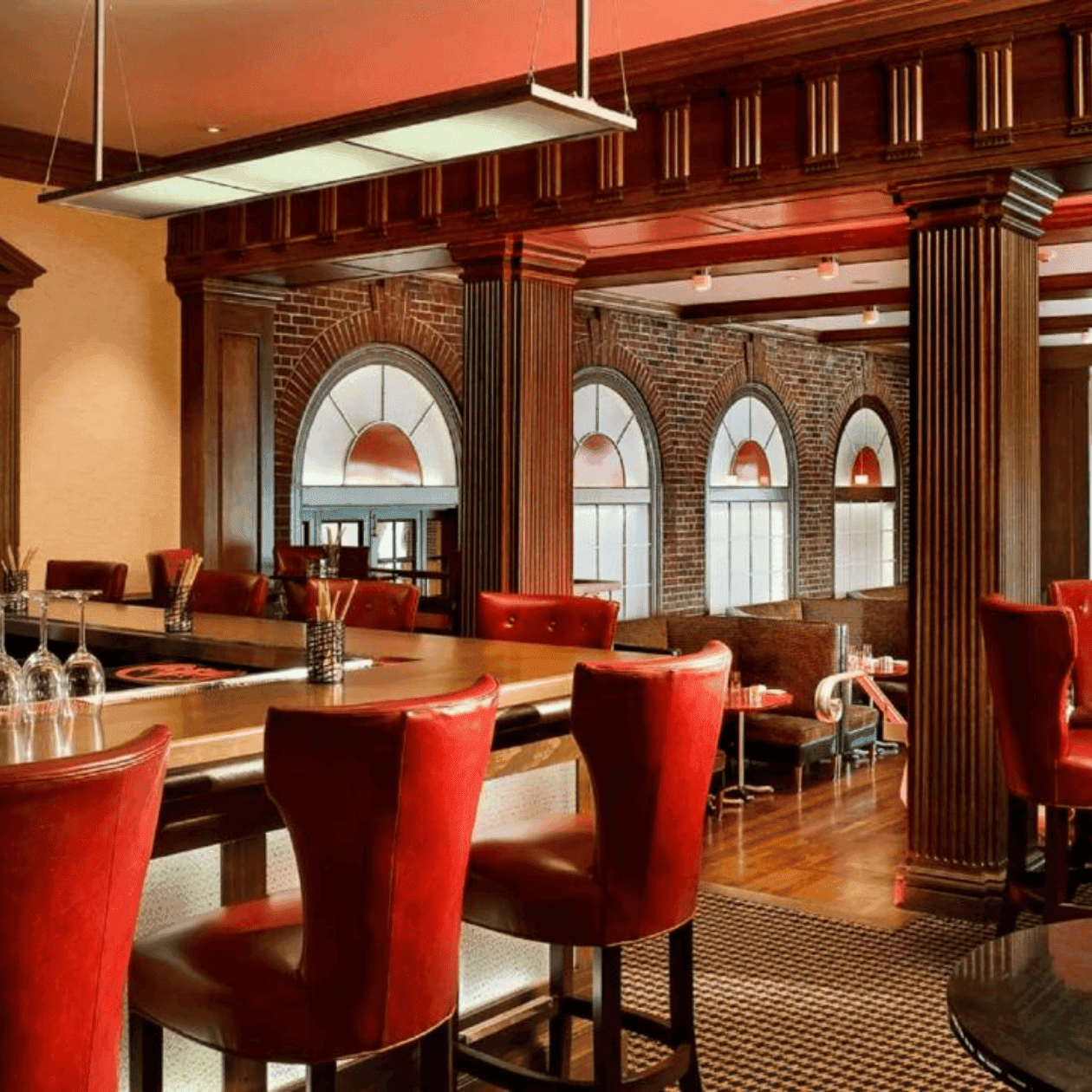 Elegant restaurant interior with red leather seating and wooden bar, introducing Epoch’s new winter menu.