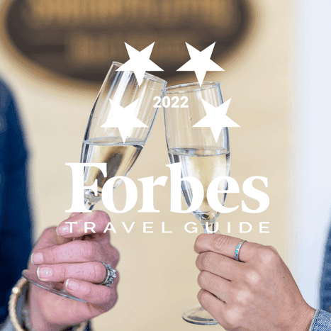 Close-up of toasting wine glasses featuring Forbes Travel Guide at The Inn at Willow Grove