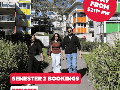 Three people walk on a path past a modern building advertising Semester 2 bookings at UniLodge @ UC - Campus West.