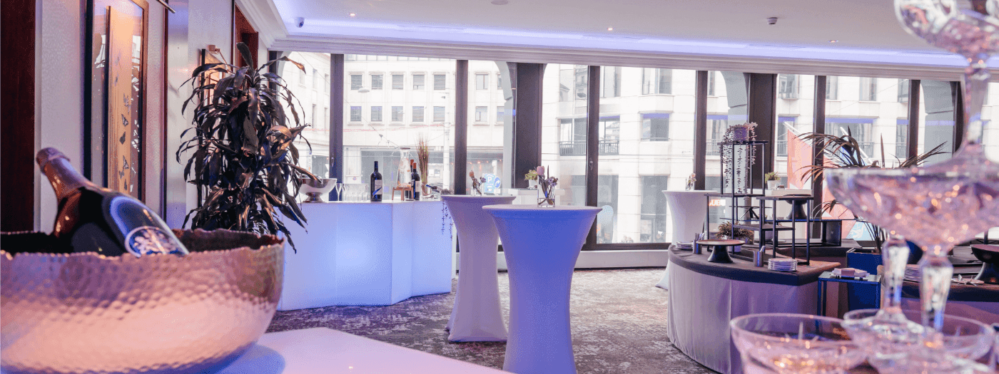 Des présentations de boissons raffinées et de grandes baies vitrées offrant une vue sur la ville au Foyer Mezzanine du Warwick Genève