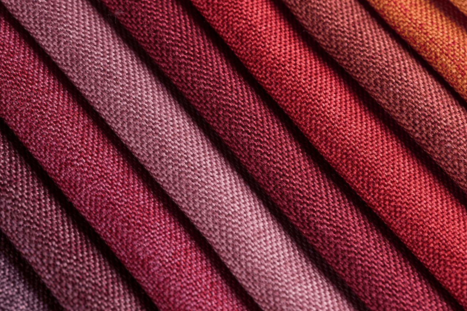 Gros plan sur un tissu texturé aux rayures diagonales dans des tons bordeaux, rose et orange à Hotel Westminster Warwick Paris