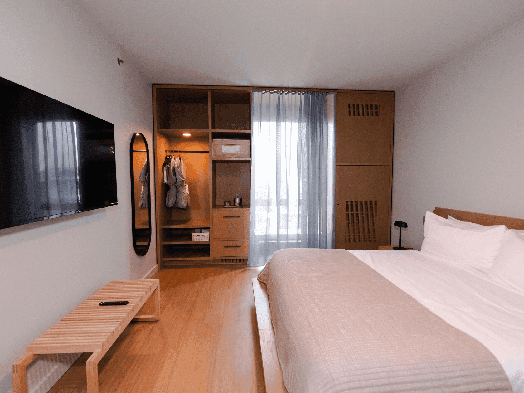 King Size Bed in Guest room with walkup closet, tv, window and standing mirror