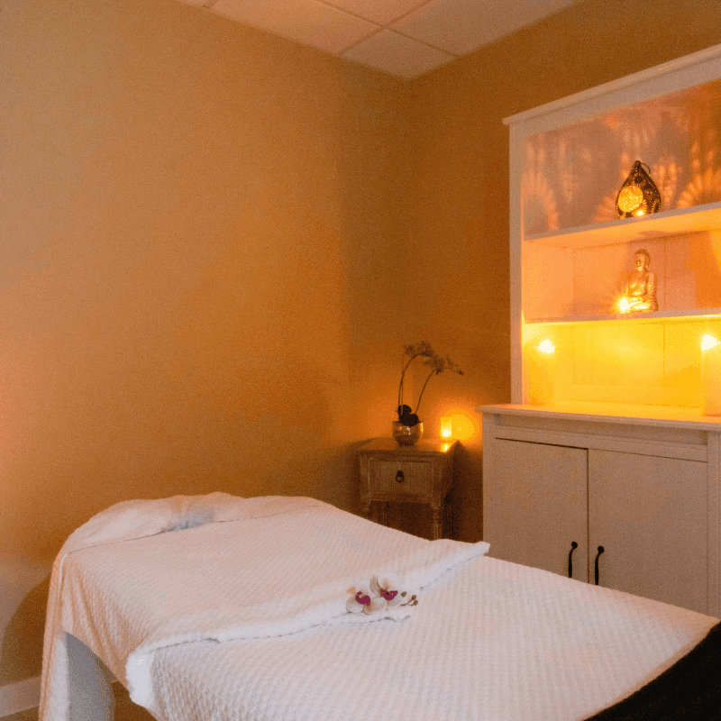 Serene spa massage room featuring a cozy treatment bed and warm ambient lighting at The Queens Hotel & Spa